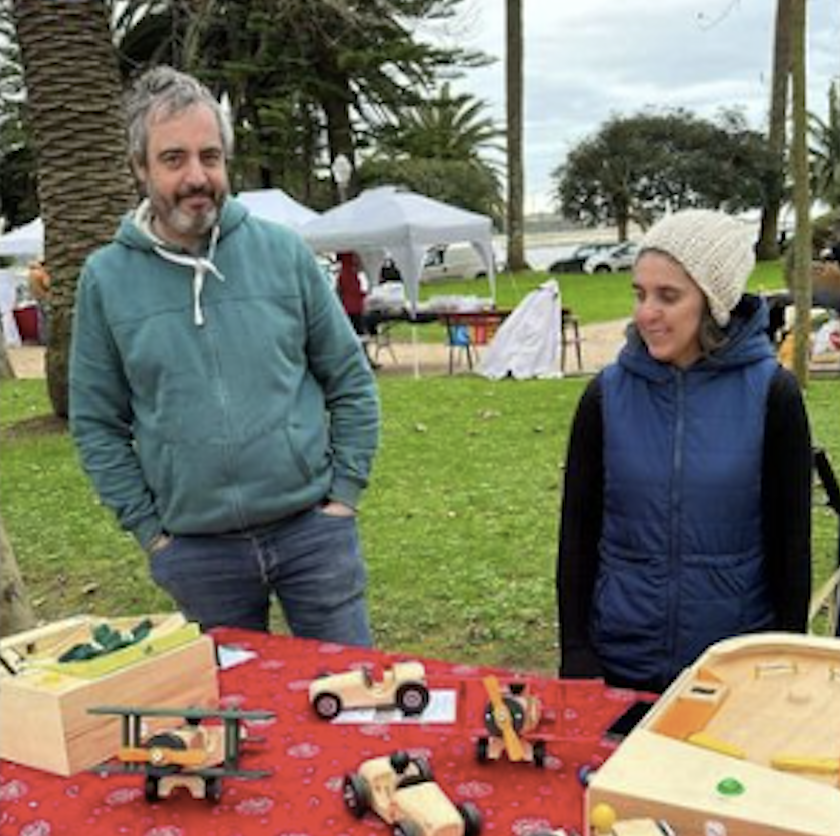 Madeirismos founders at a market stall with wooden toys